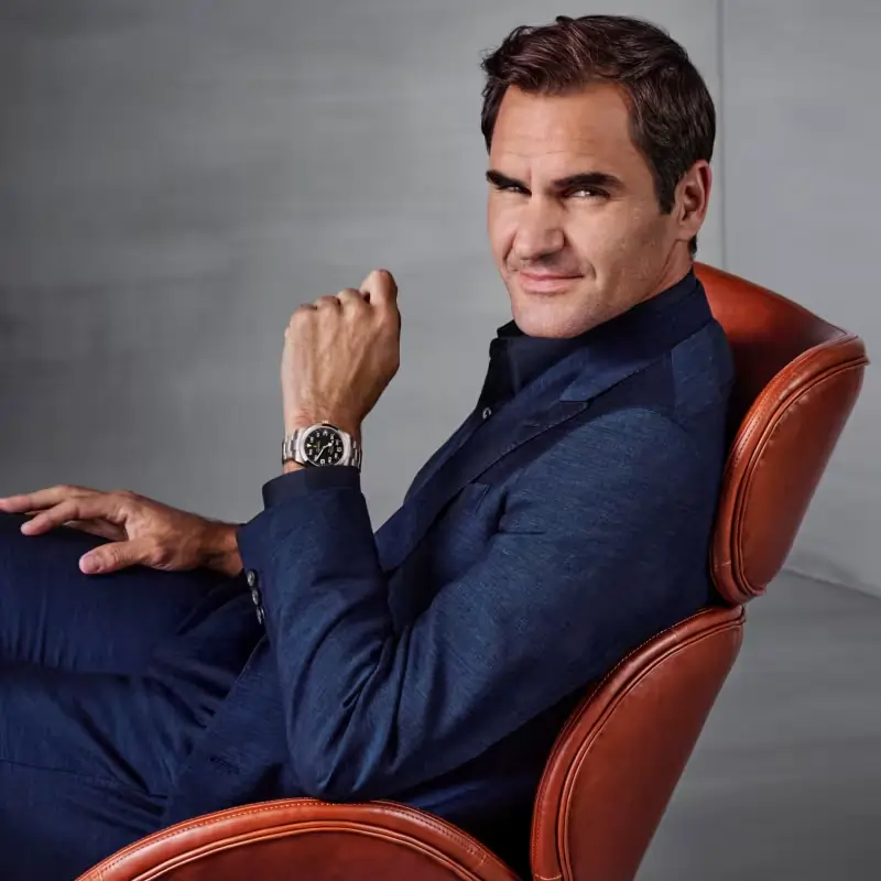 Roger Federer sentado em poltrona usando um relógio Rolex.