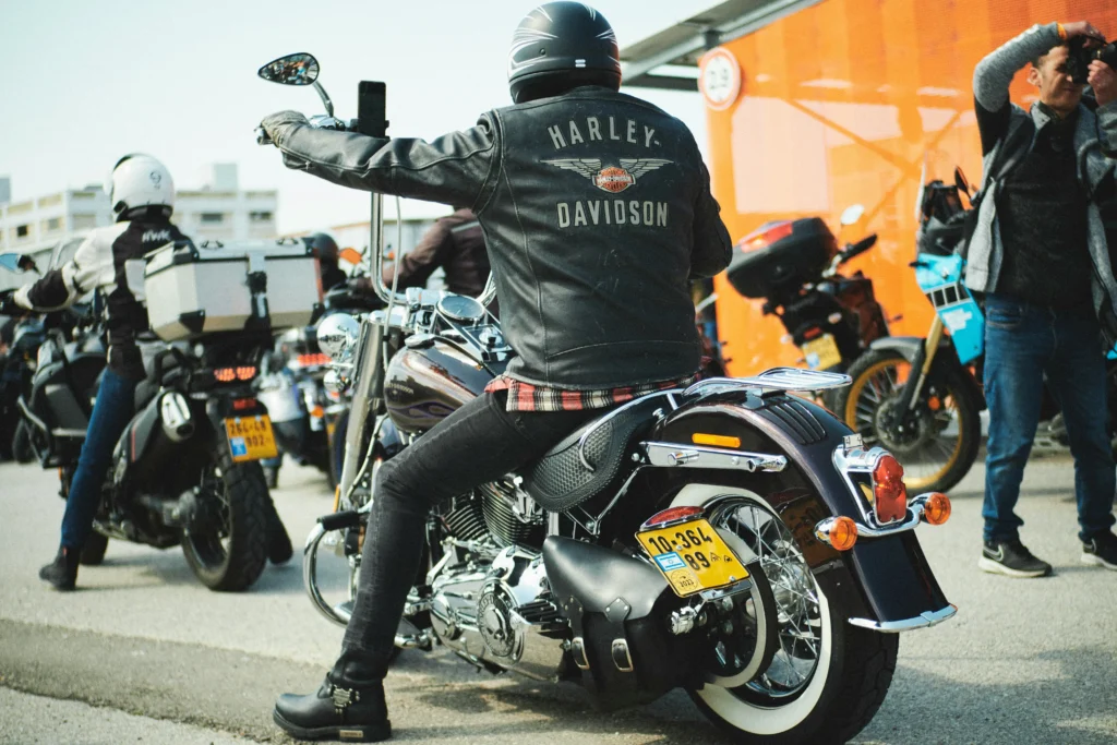 A guy on a motorcycle wearing a Harley Davidson's jacket.