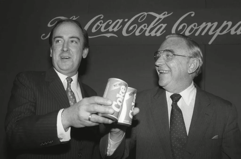 Roberto Goizueta (à esquerda), presidente do conselho e CEO da Coca-Cola Company, brindando o lançamento da New Coke com Donald Keough, presidente e diretor de operações, 1985.