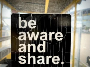 Foto de cartaz dizendo "be aware and share" (seja consciente e compartilhe).