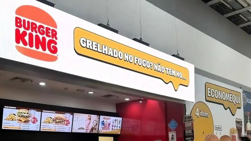Foto da fachada do Burguer King provocando a concorrência com a frase "Grelhado no fogo? Não tem no..." logo ao lado da loja do McDonald's.